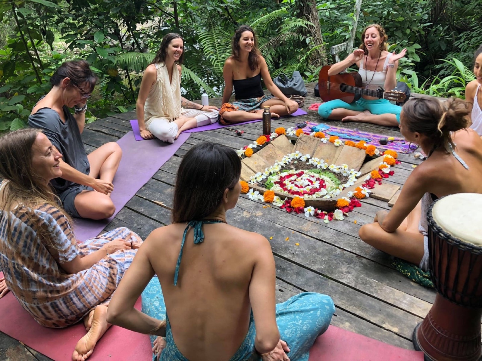 A singing circle around a flower mandala in the jungle